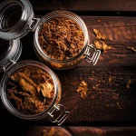 Frascos de vidrio con hojas de tabaco natural conservadas en ambiente controlado