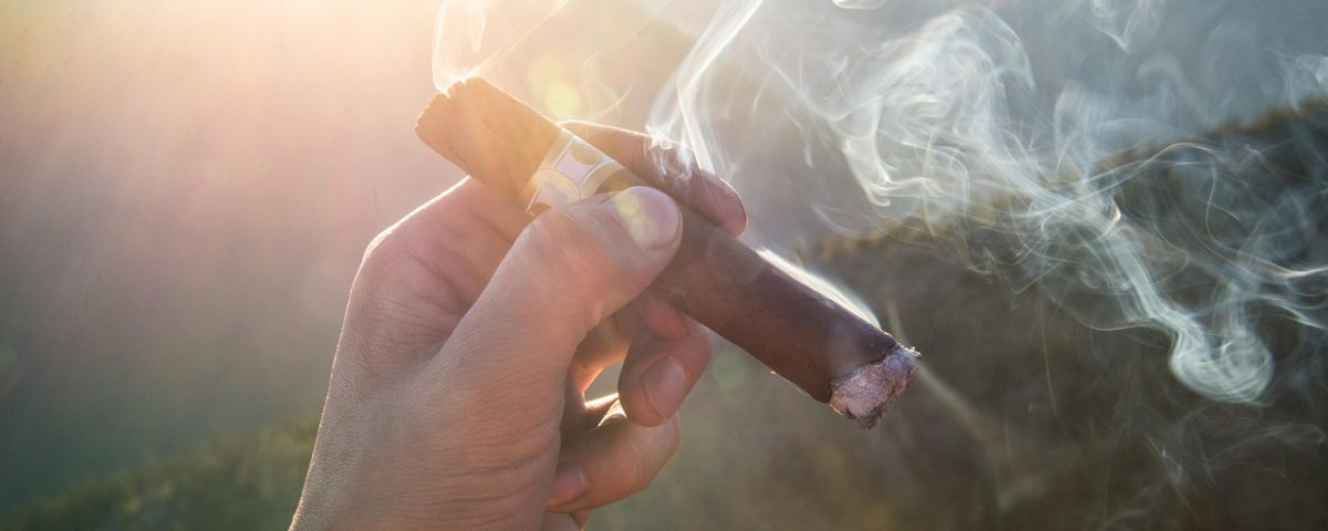 Mano liando cigarro artesanal con tabaco natural.
