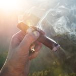 Mano liando cigarro artesanal con tabaco natural.