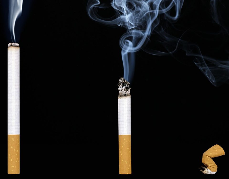 Mano liando cigarrillo con tabaco picado artesanal.